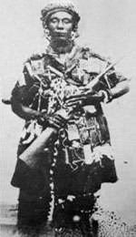 A black woman in military clothes holding a gun