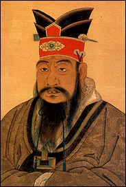 Head and shoulders of a Chinese man with a fancy red and black hat and a very long black mustache: Confucius