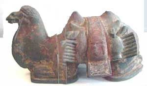 clay statuette of a camel with saddles lying down