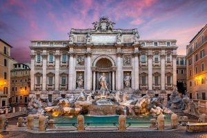 A big stone fountain with columns and sculpture